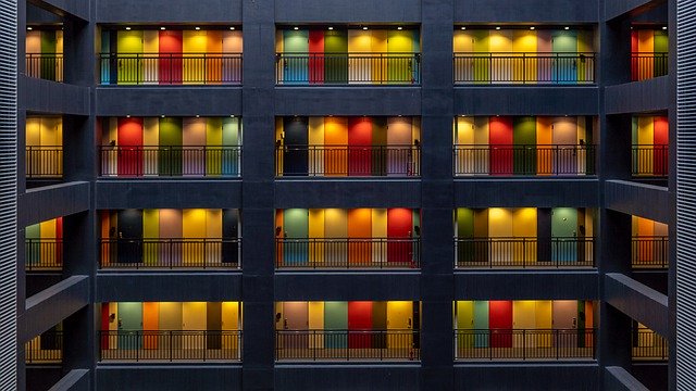 Poschodová budova s množstvom farebných dverí a balkónov
